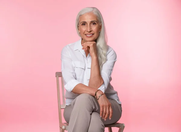 Retrato de bela mulher madura no fundo rosa — Fotografia de Stock