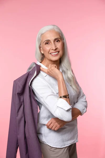 Портрет красивой зрелой женщины на розовом фоне — стоковое фото