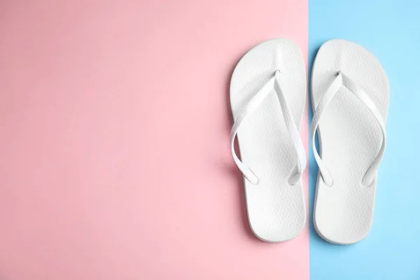 Platte lay compositie met teenslippers op kleur achtergrond, ruimte voor tekst. Strandobjecten — Stockfoto