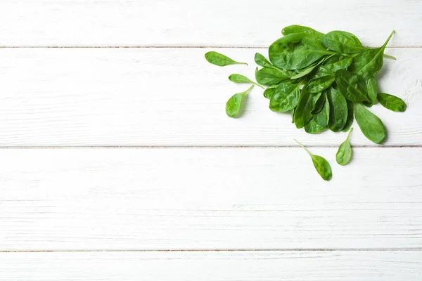 Haufen frischer grüner, gesunder Spinat auf weißem Holztisch, Draufsicht. Raum für Text — Stockfoto