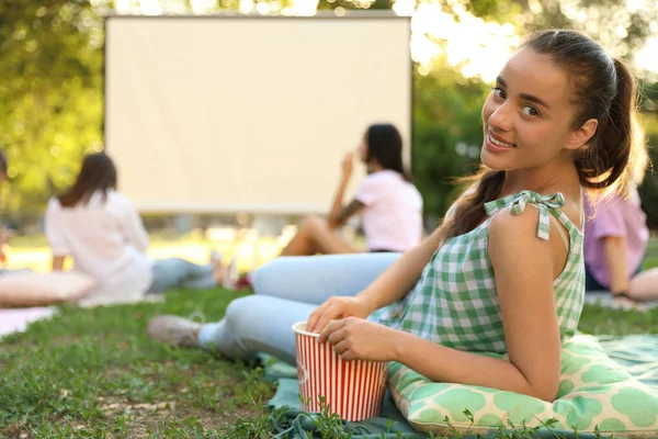 Młoda kobieta z popcorn oglądania filmu w kinie na otwartym powietrzu. Miejsce na tekst — Zdjęcie stockowe