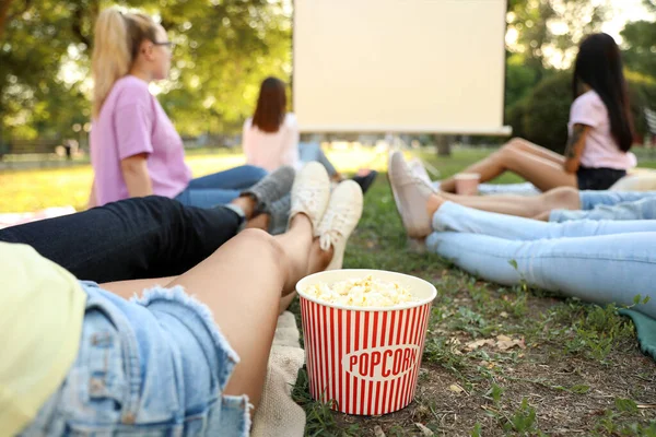 Young people with popcorn watching movie in open air cinema, closeup — Stock Photo, Image