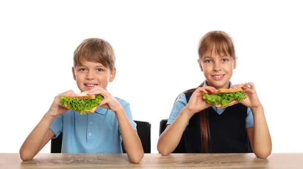 행복 한 어린이들이 하얀 배경으로 학교 식탁에서 건강 한 음식을 먹는 모습 — 스톡 사진