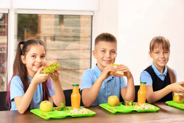 Happy children at table with healthy food in school canteen — Stock Photo, Image