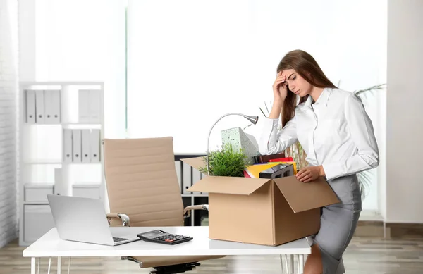 Bouleversé jeune femme emballage trucs dans la boîte au bureau — Photo