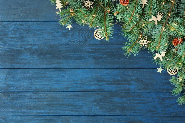 Rami di abete con decorazione natalizia su sfondo blu in legno, posa piatta. Spazio per testo — Foto Stock