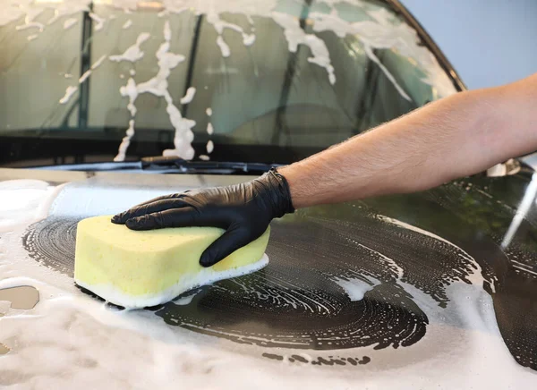 Worker cleaning automobile with sponge at car wash, closeup — Stock Photo, Image