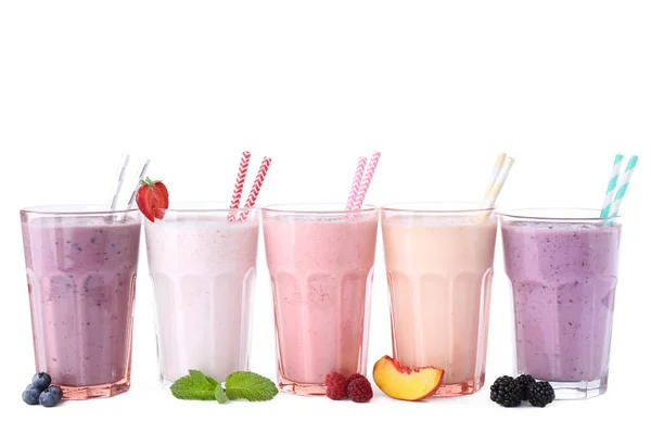 Different fresh tasty milk shakes in glasses with ingredients on white background — Stock Photo, Image