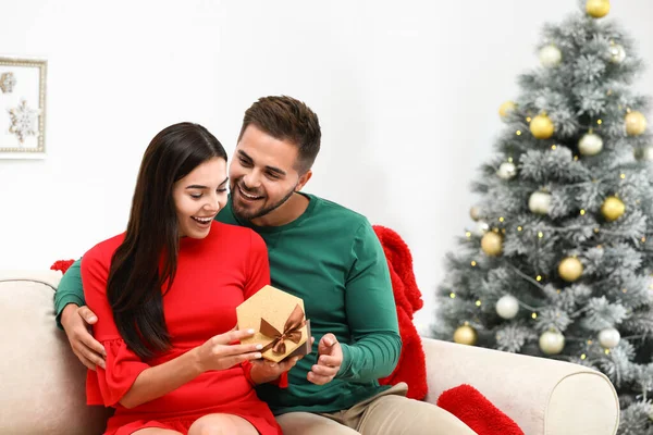 Feliz pareja joven con regalo de Navidad en casa — Foto de Stock