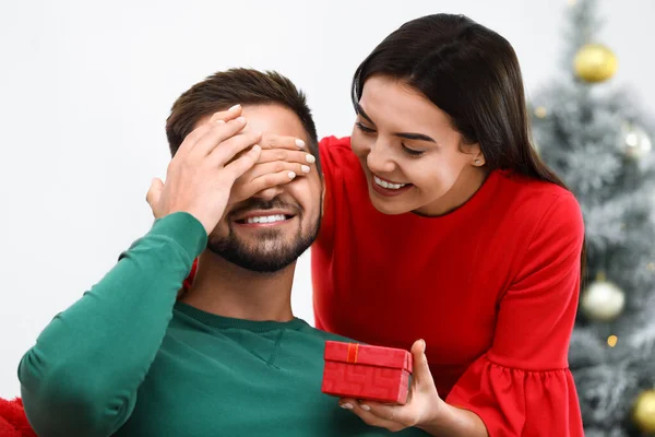 Genç bir kadın erkek arkadaşına Noel hediyesi veriyor. — Stok fotoğraf