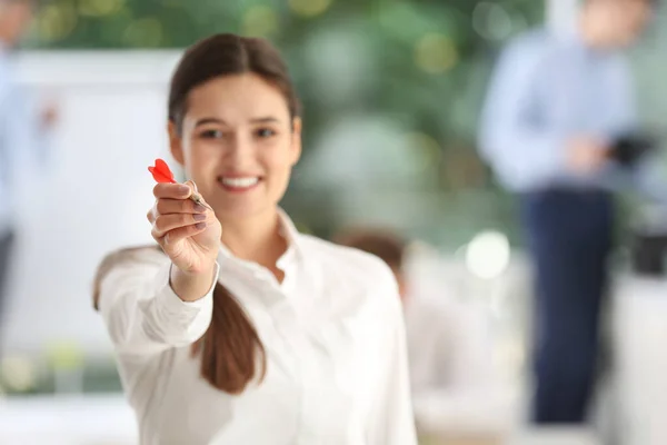Šťastná mladá podnikatelka v úřadu, se zaměřením na ruku se šipkou — Stock fotografie