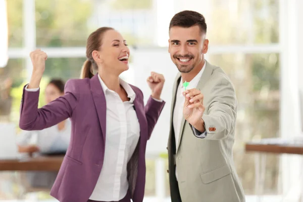 Jóvenes empleados felices con dardos en la oficina — Foto de Stock