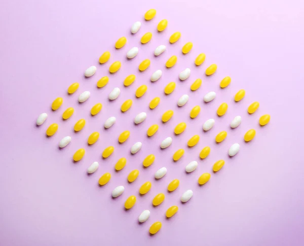 Coloridas gominolas sobre fondo lila, planas — Foto de Stock