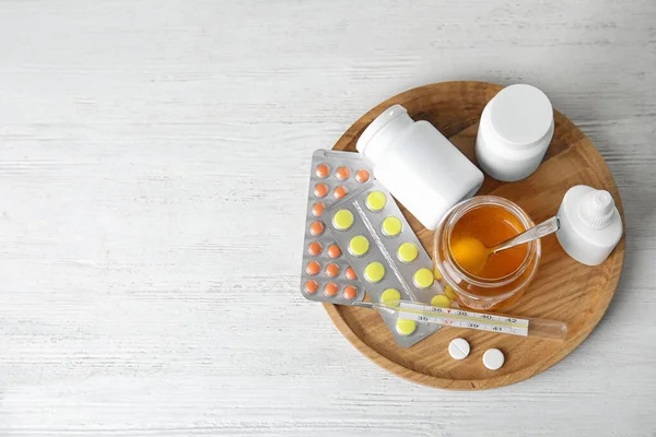 Tray with different cold remedies on white wooden table, top view. Space for text