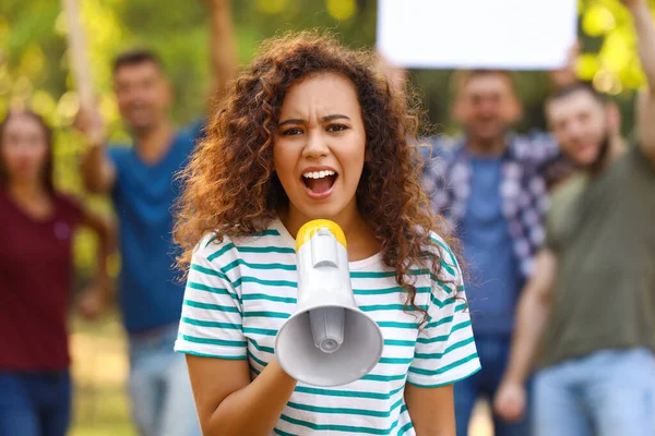 Angry African-American woman with megaphone at protest outdoors