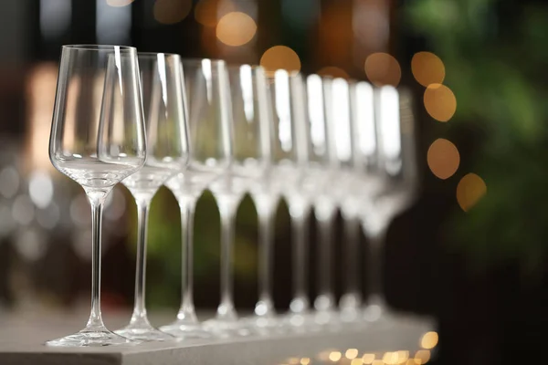 Set lege wijnglazen op grijze tafel tegen wazige achtergrond — Stockfoto