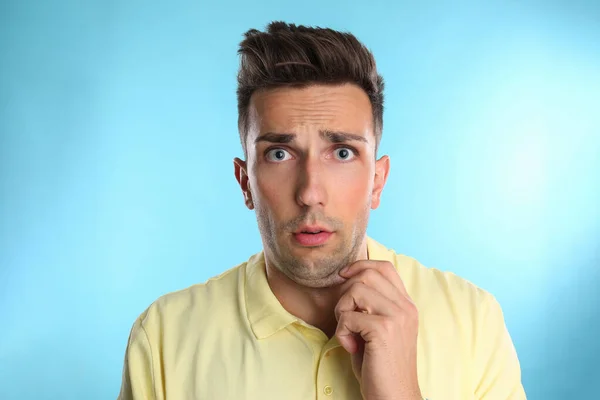 Эмоциональный молодой человек с двойным подбородком на синем фоне — стоковое фото