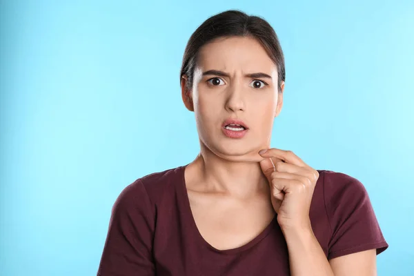 Mujer joven emocional con doble barbilla sobre fondo azul —  Fotos de Stock