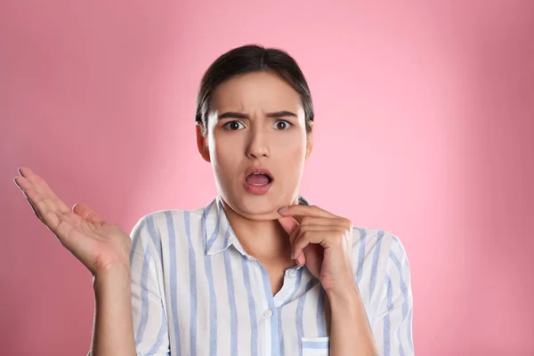 Emotionale junge Frau mit Doppelkinn auf rosa Hintergrund — Stockfoto