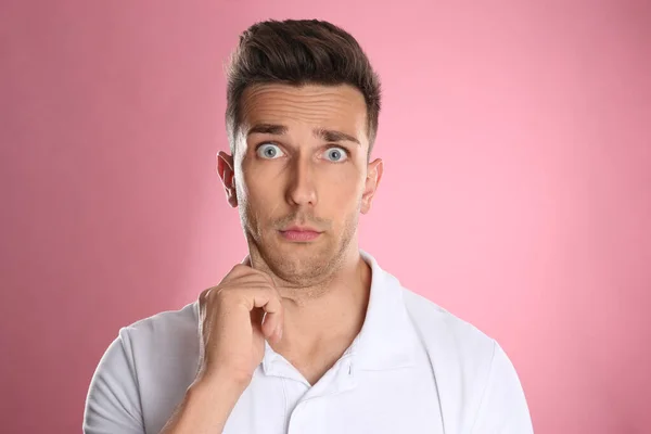 Känslomässig ung man med dubbel haka på rosa bakgrund — Stockfoto