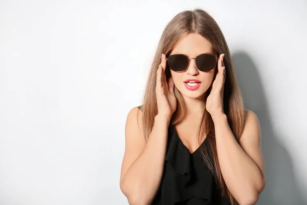 Young woman wearing stylish sunglasses on light background. Space for text — Stock Photo, Image