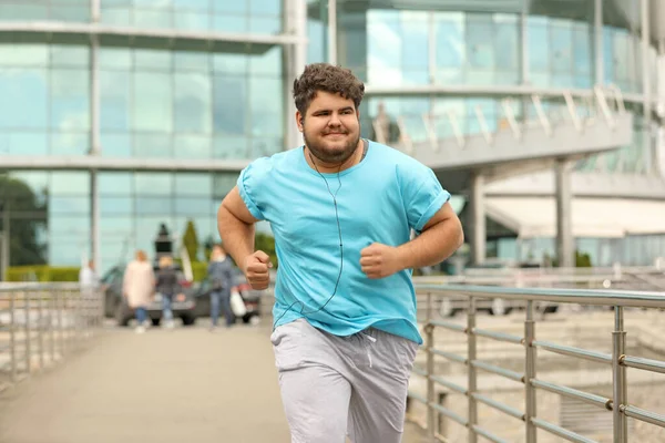 Un giovane sovrappeso che corre all'aperto. Stile di vita fitness — Foto Stock