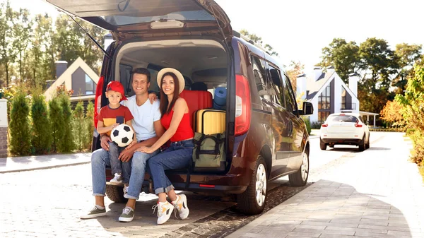 행복 한 가족 이 야외의 자동차 트렁크에 앉아 있었다. 움직이는 날 — 스톡 사진