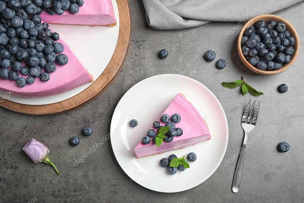 Flat lay composition of tasty blueberry cake on grey table
