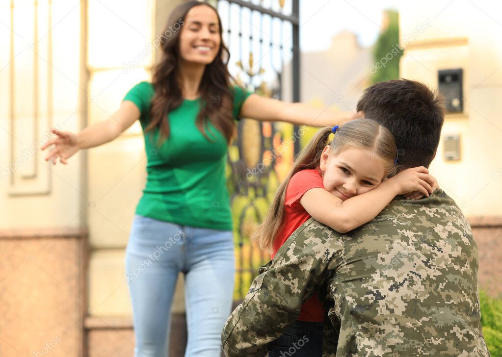 Man in military uniform and his family outdoors