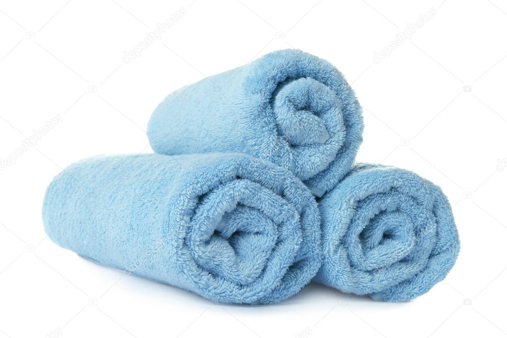 Rolled clean turquoise towels on white background