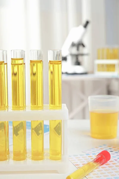 Tubes à essai avec échantillons d'urine pour analyse sur table blanche en laboratoire — Photo