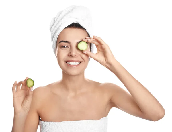 Happy young woman with towel holding cucumber slices on white background. Organic face mask — ストック写真