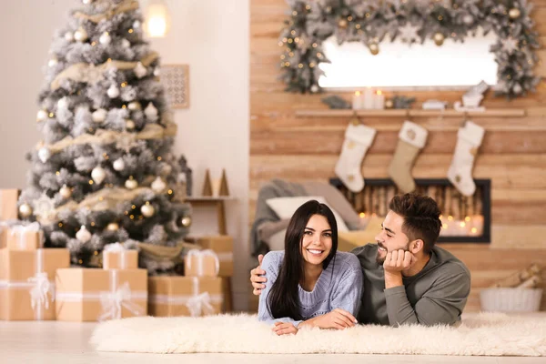 Pareja feliz en la sala de estar decorada para Navidad — Foto de Stock
