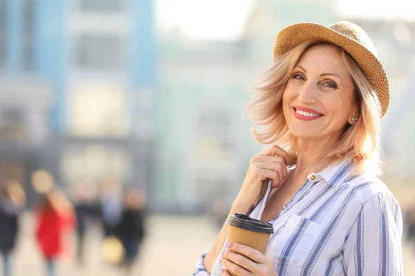 Hermosa mujer madura con taza de café al aire libre — Foto de Stock