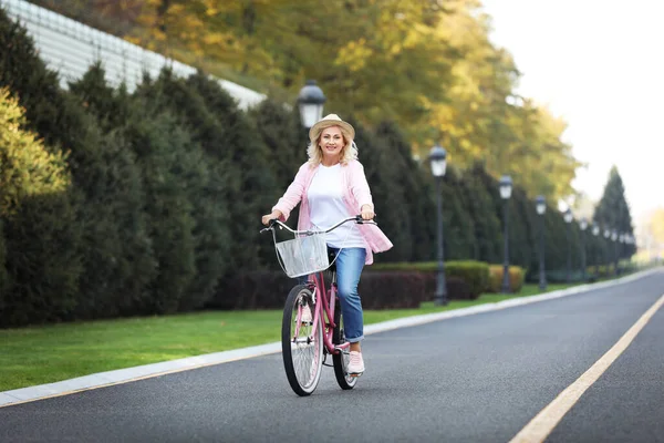 Mujer madura montando bicicleta al aire libre. Estilo de vida activo — Foto de Stock