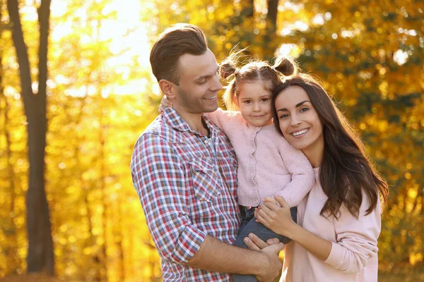 Familia feliz con una hija pequeña en el parque. Caminata de otoño — Foto de Stock