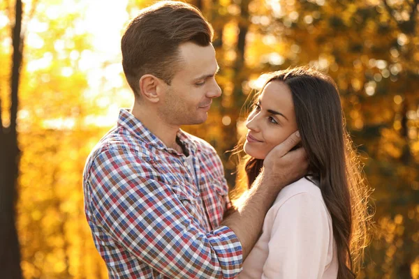 Um casal feliz num parque ensolarado. Passeio de outono — Fotografia de Stock