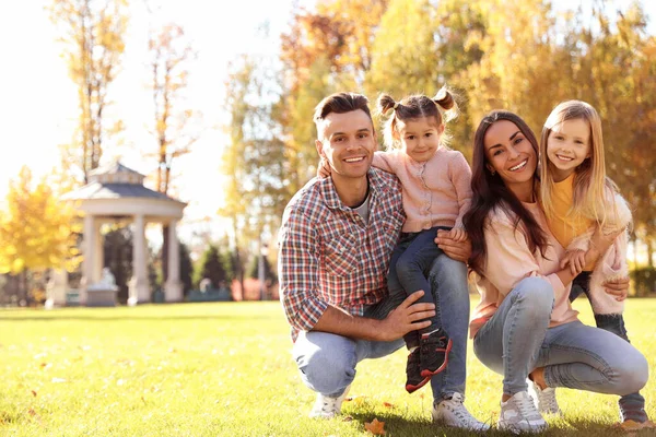 Glückliche Familie mit kleinen Töchtern im Park. Herbstwanderung — Stockfoto