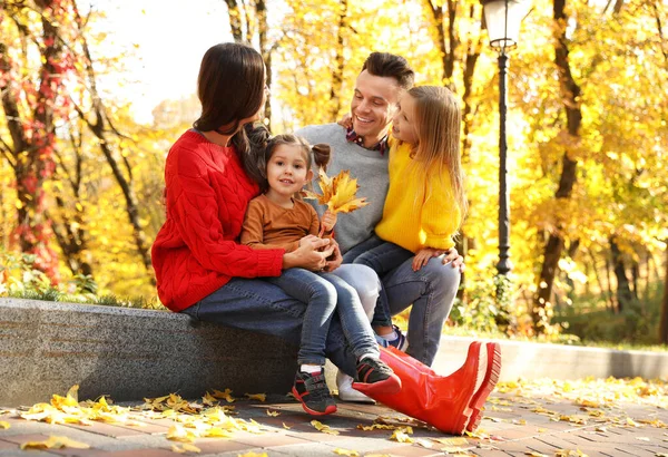 Счастливая семья с маленькими дочерьми в парке. Осенняя прогулка — стоковое фото