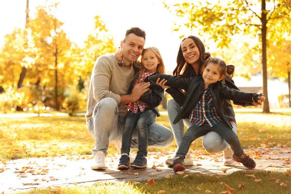 Šťastná rodina s malými dětmi ve slunečném parku. Podzimní procházka — Stock fotografie