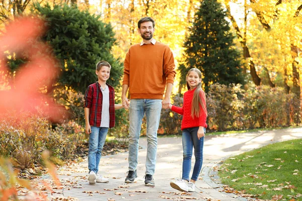 Šťastný otec s dětmi procházky v podzimním parku — Stock fotografie