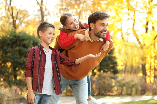 Счастливый отец и дети проводят время в парке. Осенняя прогулка — стоковое фото