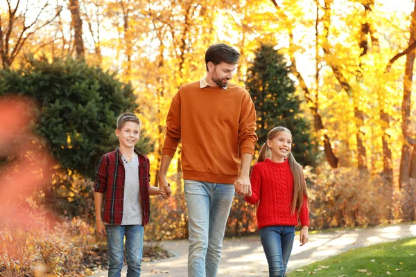 Padre feliz con los niños caminando en el parque de otoño — Foto de Stock