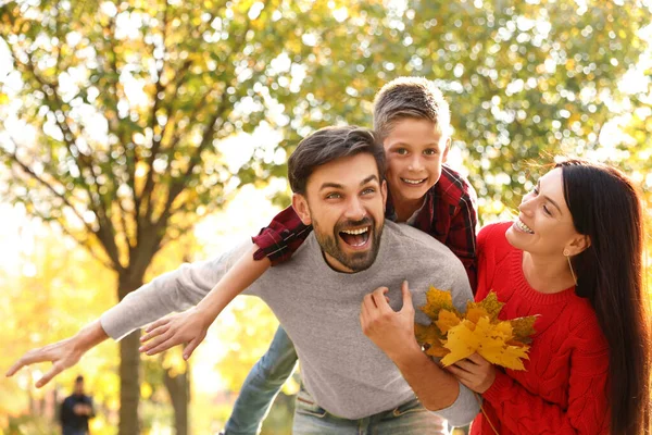 Šťastná rodina se synem tráví čas v parku. Podzimní procházka — Stock fotografie