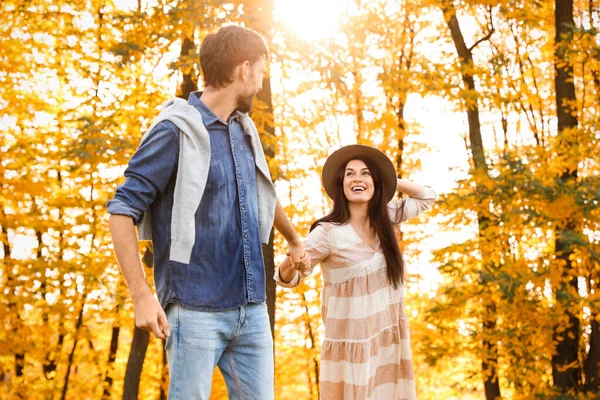 Glückliches Paar spaziert in sonnigem Herbstpark — Stockfoto
