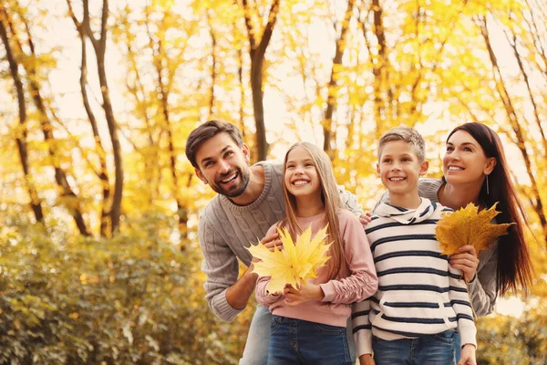 Счастливая семья с детьми проводит время в парке. Осенняя прогулка — стоковое фото