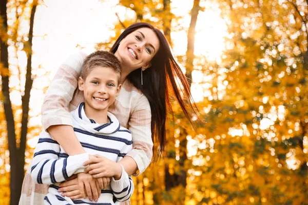 Happy mother with son in sunny park. Autumn walk — Stock fotografie
