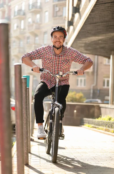 Guapo feliz hombre en casco a caballo bicicleta en la calle de la ciudad — Foto de Stock