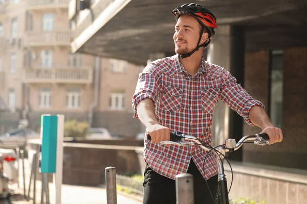 Guapo feliz hombre en casco a caballo bicicleta en la calle de la ciudad — Foto de Stock