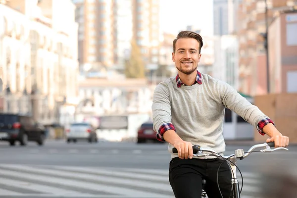 Beau homme heureux à vélo sur la rue de la ville — Photo